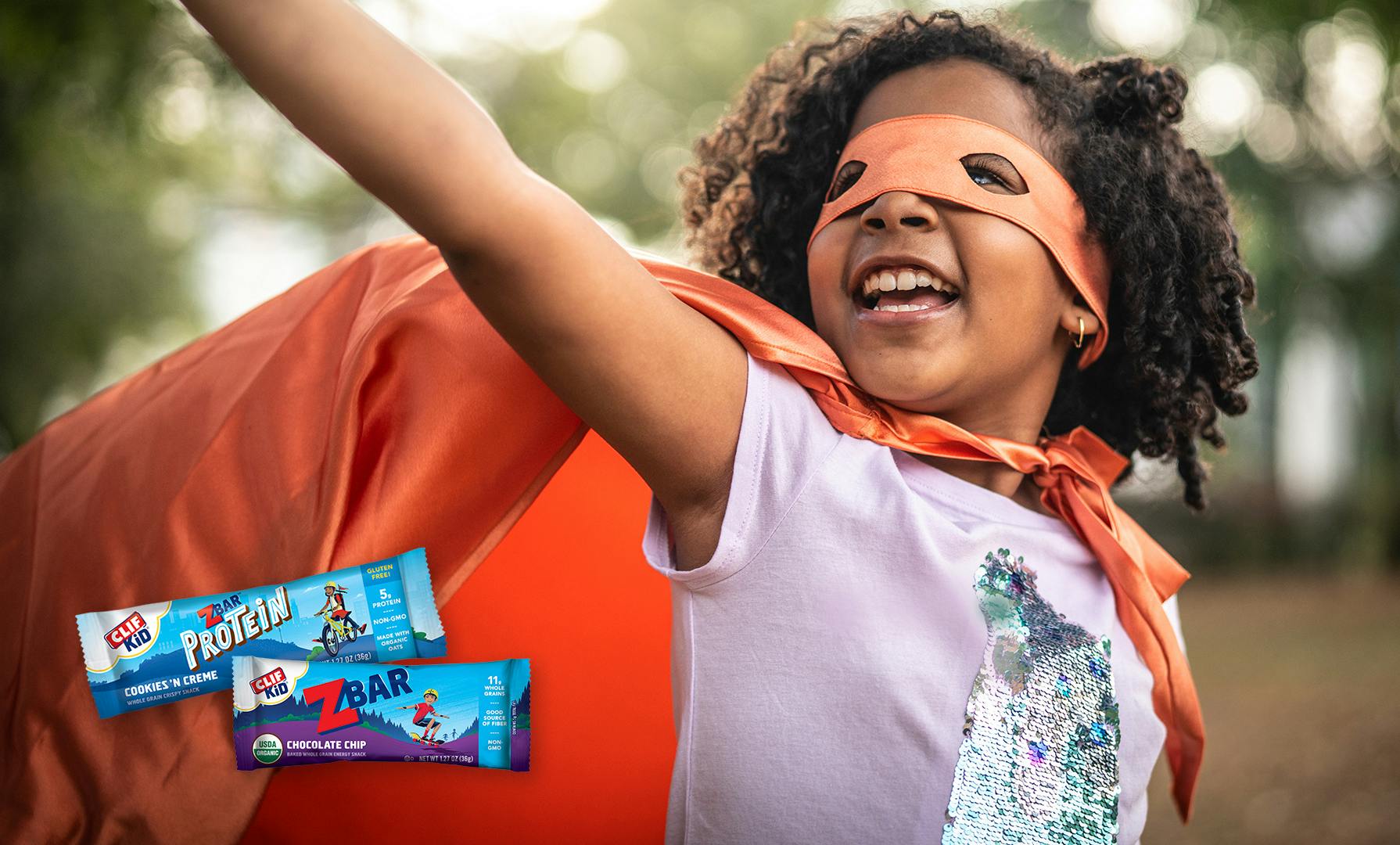 Girl in mask and cape with CLIF Kid bars